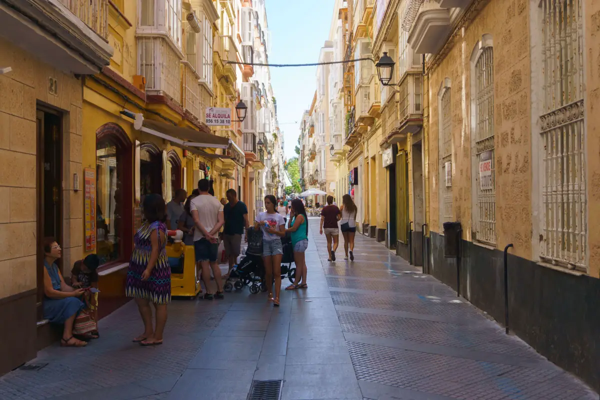 Menschen in einer Gasse in der Altstadt von Cadiz