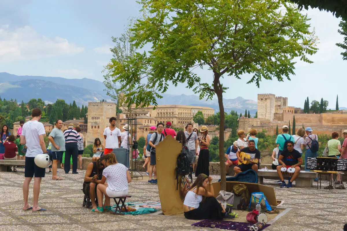Touristen und Straßenverkäufer am Mirador San Nicolás in Granada Andalusien