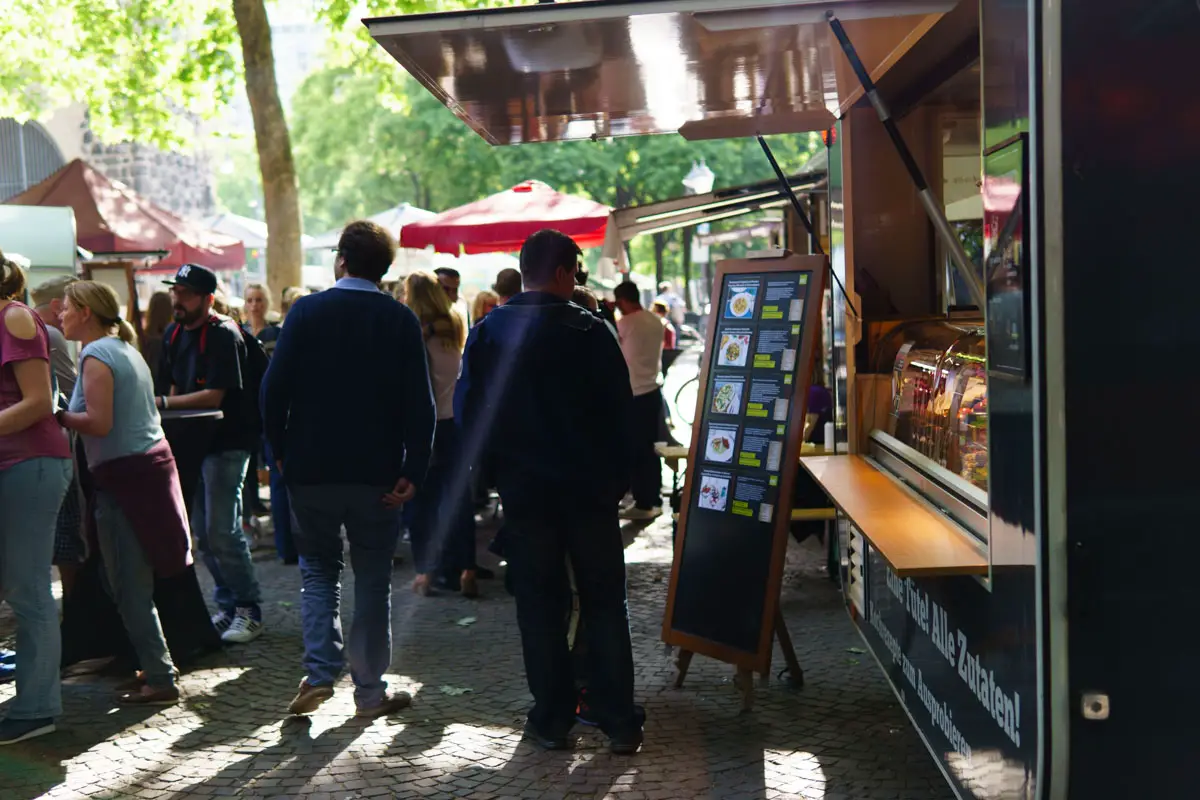 Foodtrucks und Menschen auf dem Streetfoodmarkt in Köln