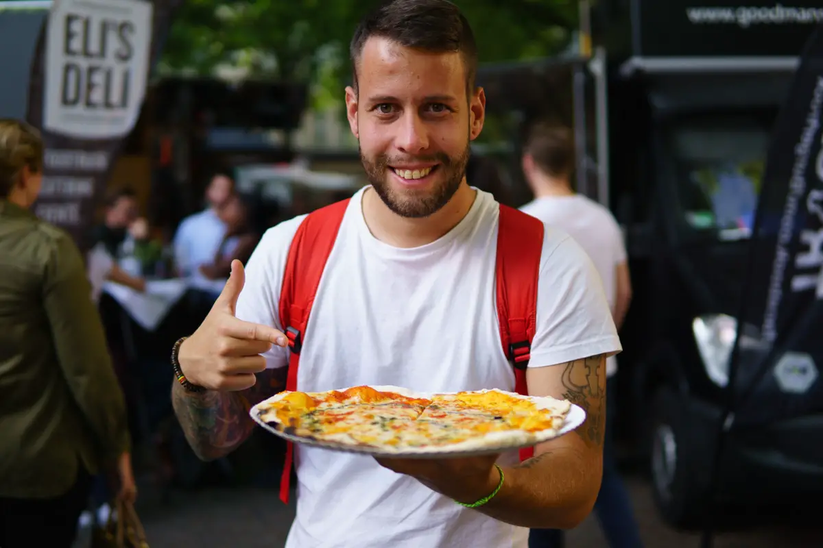Marco mit einer Pizza auf dem Streetfoodmarkt in Köln
