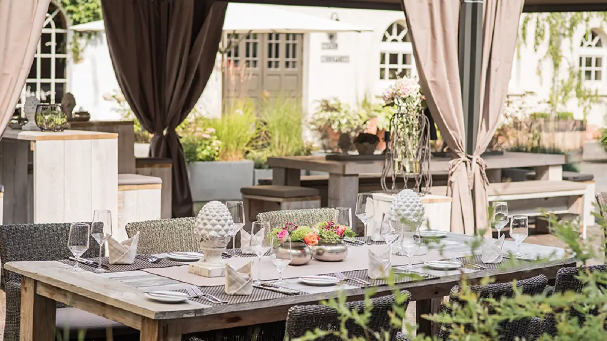 Schön dekorierter Tisch mit Sitzgelegenheiten im Gartenbereich des Hotels