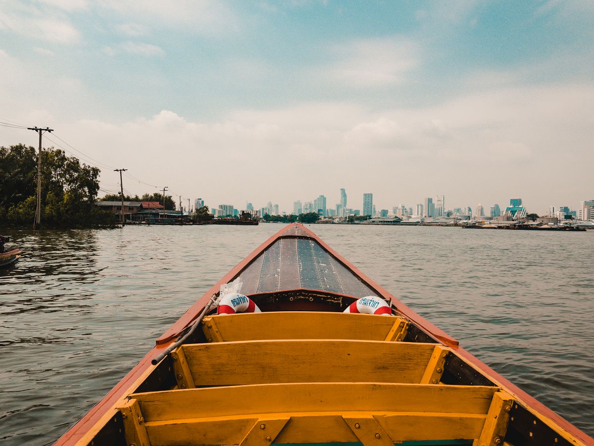 Kleine Bootfähre mit Sicht auf Bangkoks Skyline