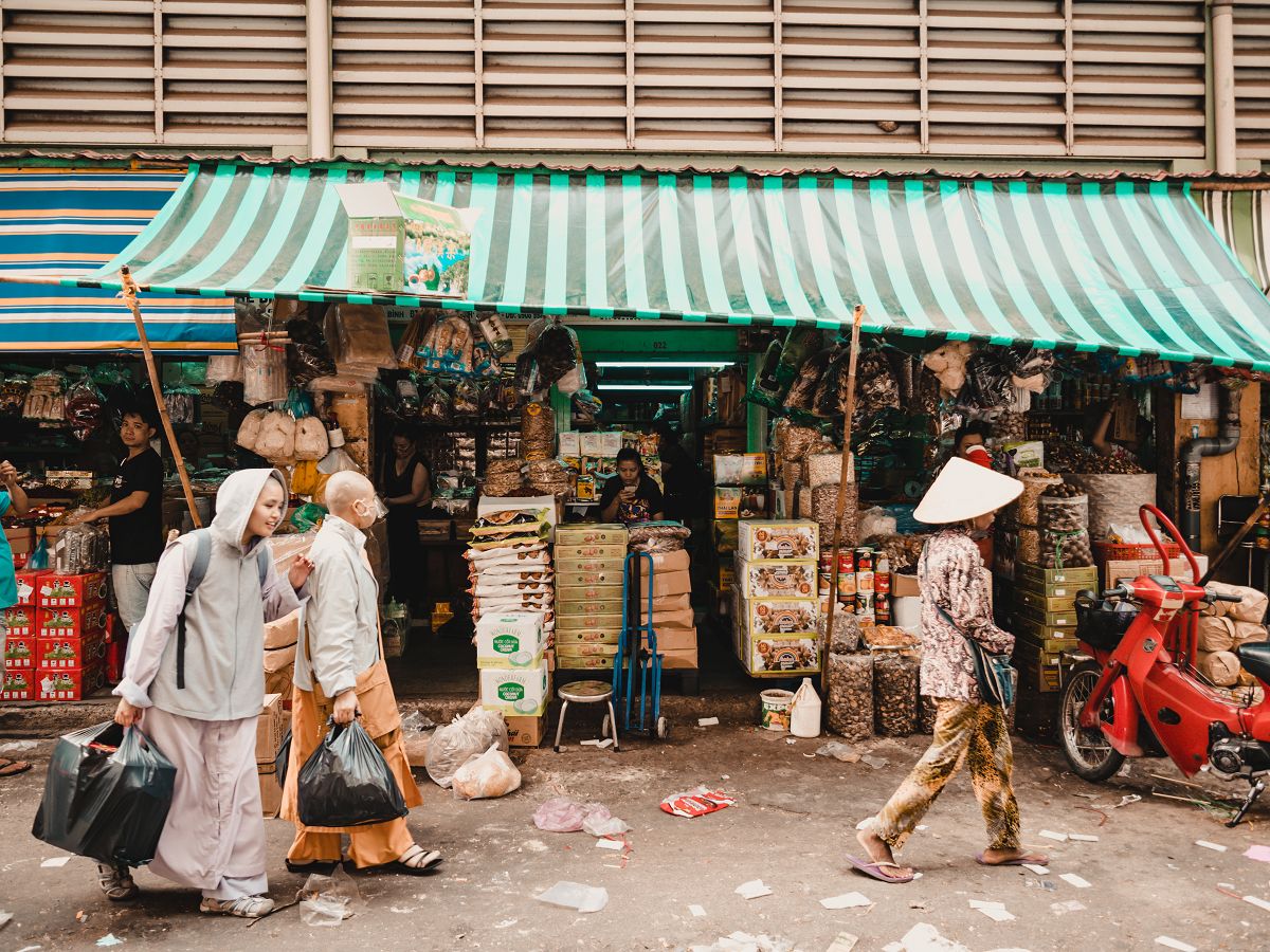 Vietnamesen und ein Stand im Binh Tay Market in Saigon