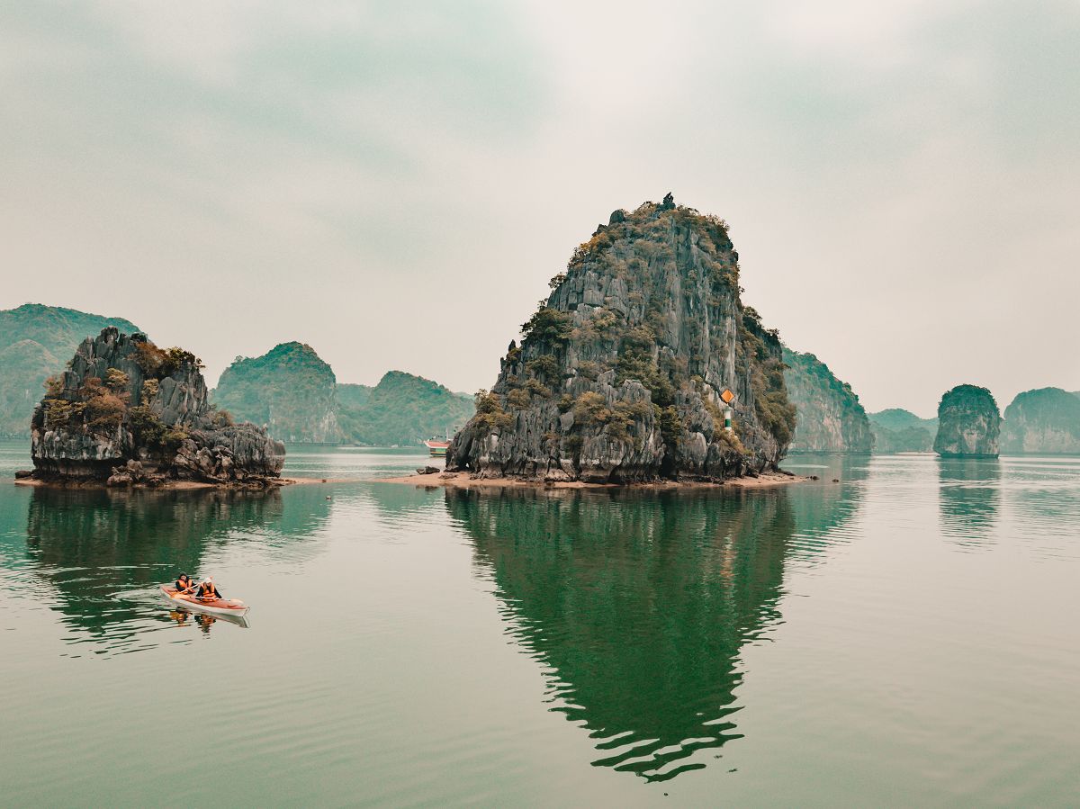 Kajak fahrer und Kalksteinfelsen in der Halong Bucht Vietnam