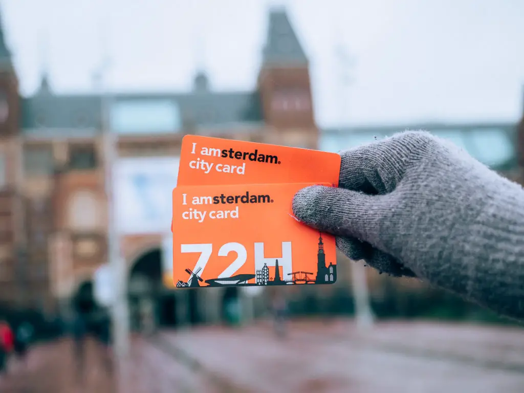 Sara hält die I Amsterdam city card in der Hand.
