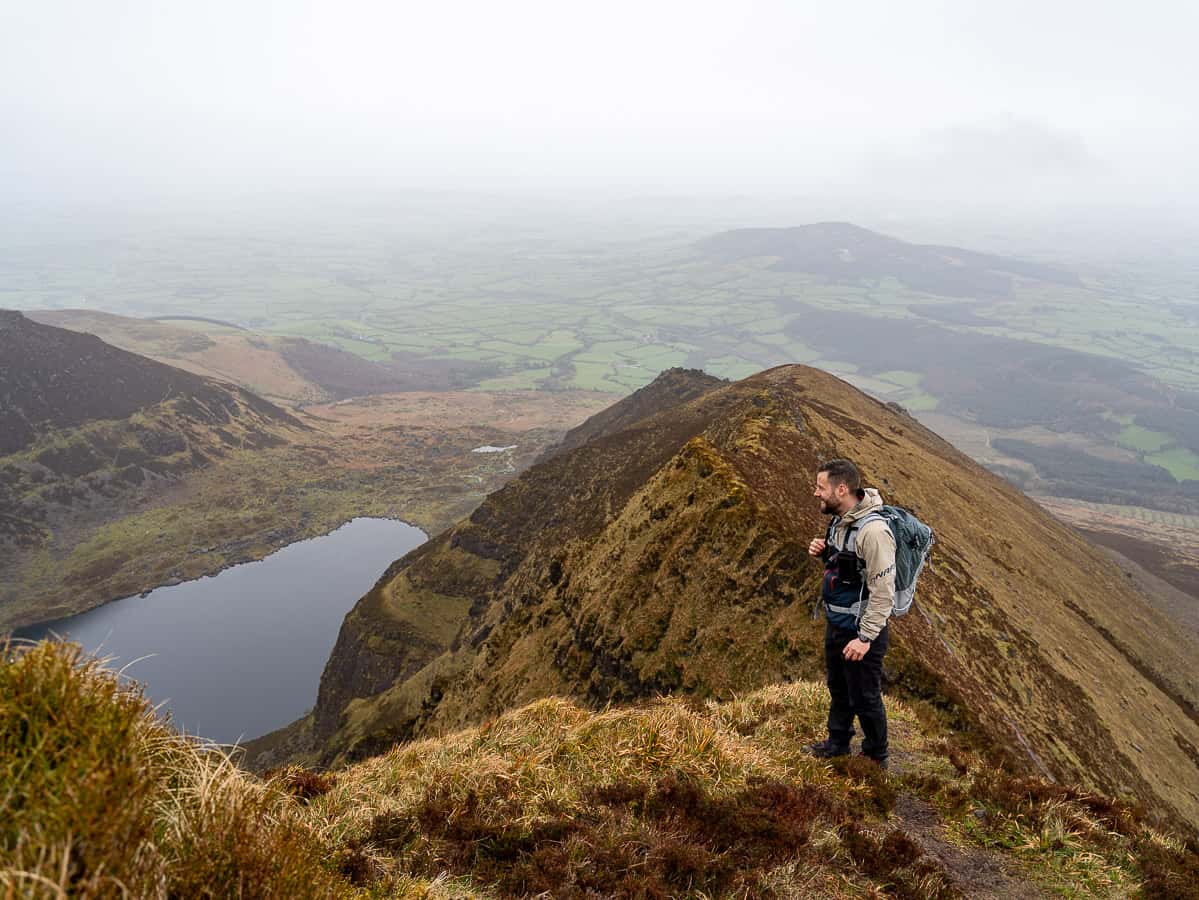 Marco mit Blick auf die Klippen und den See Coumshingaun in Irland